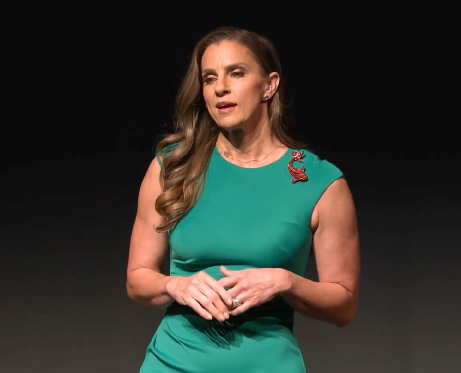 MaryAnne Karstadt close up speaking in a green dress at the Tempe Center for the Arts